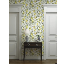 Kamerzicht met behang met citroen- en olijfmotief, commode, lamp en witte deuren.