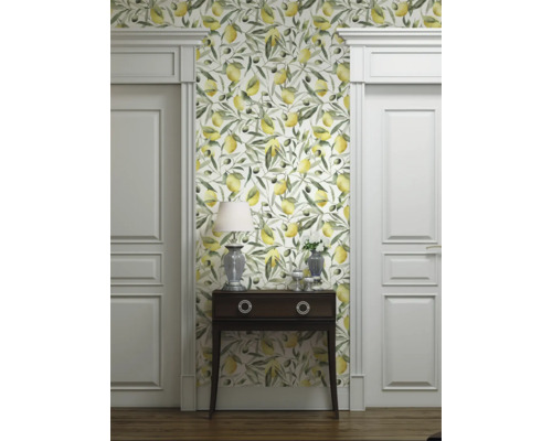 Kamerzicht met behang met citroen- en olijfmotief, commode, lamp en witte deuren.