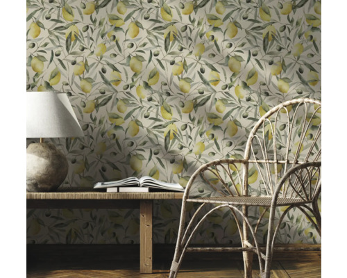 Decoratieve kamer met een behang met citroenen en olijftakken, een houten tafel, een lamp, een boek en een rotan stoel.