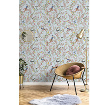 Decoratieve kamer met behang met vogelmotief, fauteuil, vloerlamp, spiegel, kamerplant en tapijt