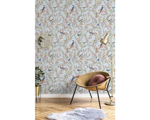 Decoratieve kamer met behang met vogelmotief, fauteuil, vloerlamp, spiegel, kamerplant en tapijt