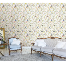 Licht, vriendelijk interieur met bloemenbehang met vogels, bank en fauteuil