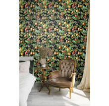 Slaapkamer met bed, fauteuil en wandbekleding met fruitmotieven.