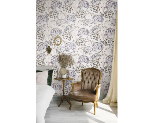 Gedecoreerde kamer met bed, fauteuil, bijzettafel en bloemenbehang