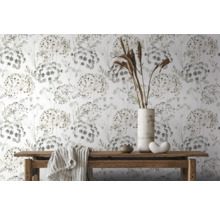 Decoratief behang met bloemmotief op een witte achtergrond, samen met een houten tafel met decoraties en een doek