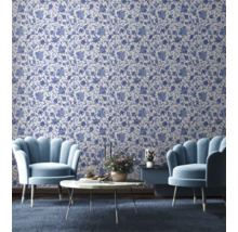 Woonkamer met bloemenbehang, twee fauteuils, een salontafel en een bijzettafel.