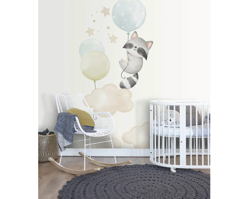 Kinderkamer met muurschildering van een wasbeer aan ballonnen, een schommelstoel en een rond kinderbed