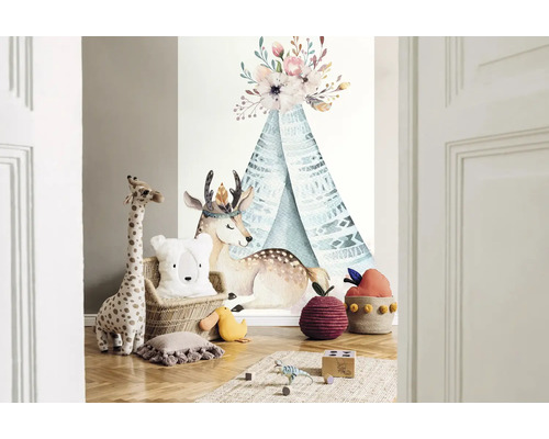 Decoratieve kinderkamer met muursticker, speelgoedgiraffe, berenkussen en tapijt