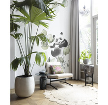 Woonkamer met palmboom in pot, fauteuil, tapijt en muursticker