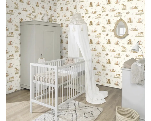 Kinderkamer met ledikant, commode en kast voor een behang met dierenmotieven.