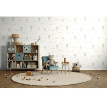 Kinderkamer met speelgoedrek, fauteuil, tafel en speelgoed op een rond vloerkleed