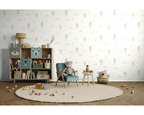 Kinderkamer met speelgoedrek, fauteuil, tafel en speelgoed op een rond vloerkleed