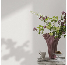 Decoratieve bloemenvaas met bloemen, koffiekop en gebak op een bijzettafel