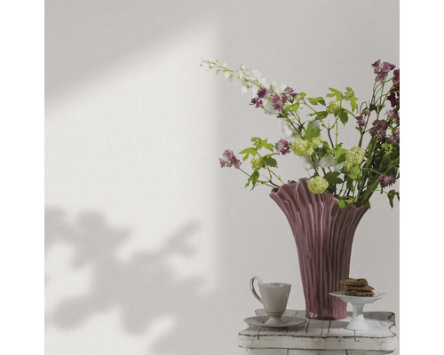 Decoratieve bloemenvaas met bloemen, koffiekop en gebak op een bijzettafel