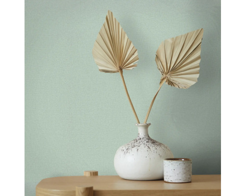 Behang met textielpatroon, vaas met waaierbladeren op een tafel