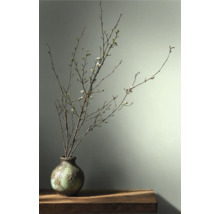 Decoratieve takken met bloesems in een vaas op een tafel