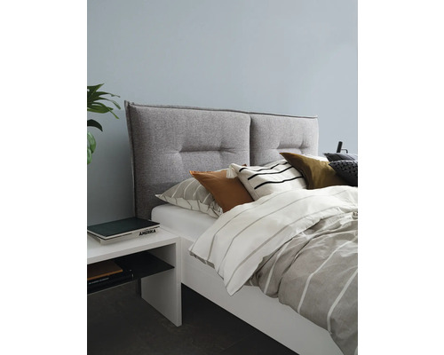 Slaapkamer met bed, gestoffeerd hoofdeinde, kussens en nachtkastje