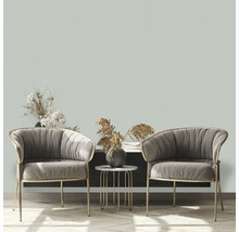 Twee grijze fauteuils met een bijzettafel en decoratieve elementen in een woonkamer