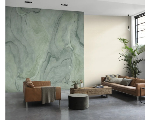 Woonkamer met gemarmerde muurdecoratie in groene tinten, leren bank en houten tafel