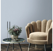 Decoratieve woonkamer met fauteuil en bijzettafel met bloemstuk.