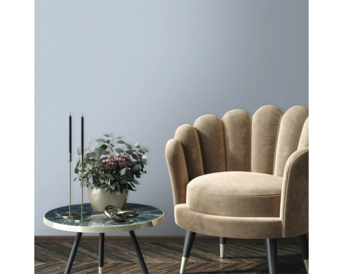 Decoratieve woonkamer met fauteuil en bijzettafel met bloemstuk.