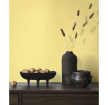 Decoratieve scène met schaal op voetjes gevuld met walnoten, een vaas met decoratie en een pot op een tafel