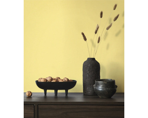 Decoratieve scène met schaal op voetjes gevuld met walnoten, een vaas met decoratie en een pot op een tafel