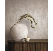 Decoratief stilleven met vaas, plant en kaars op een dressoir voor een wandbehang.