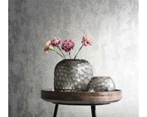 Decoratieve zilverkleurige vazen met bloemen op een bijzettafel