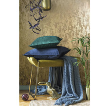 Decoratieve opstelling met kussens, kruk, deken, plant en decoratief figuur voor een gezellige sfeer