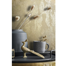 Decoratieve stilleven scène met goudkleurig behang, vaas, kop en pauwenbeeldje