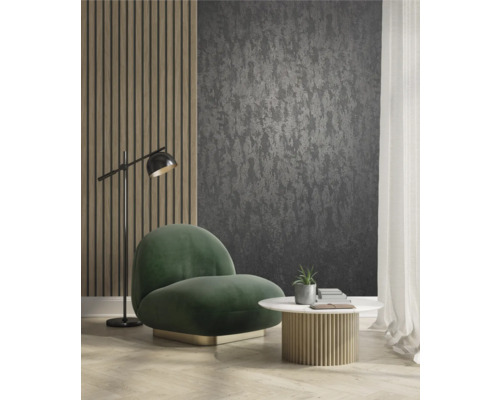 Woonkamer met donker behang met motief, fauteuil, tafel en vloerlamp