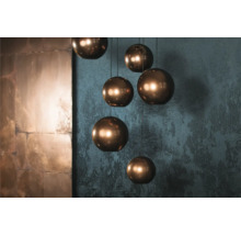 Meerdere ronde hanglampen met een metalen structuur hangen aan het plafond.