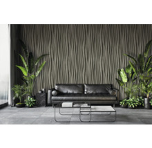 Woonkamer met zwarte bank, salontafel en decoratieve wandbekleding