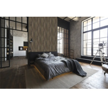 Slaapkamer in loftstijl met bed, decoratieve wandbekleding en grote ramen