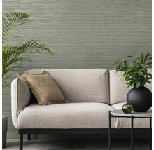 Woonkamer met textielbehang, bank, kussen, tafel en kamerplanten voor een gezellige sfeer