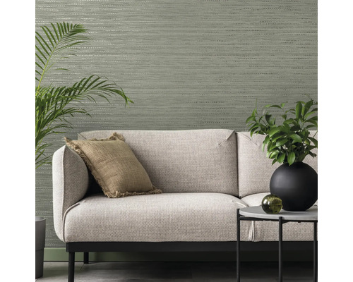 Woonkamer met textielbehang, bank, kussen, tafel en kamerplanten voor een gezellige sfeer