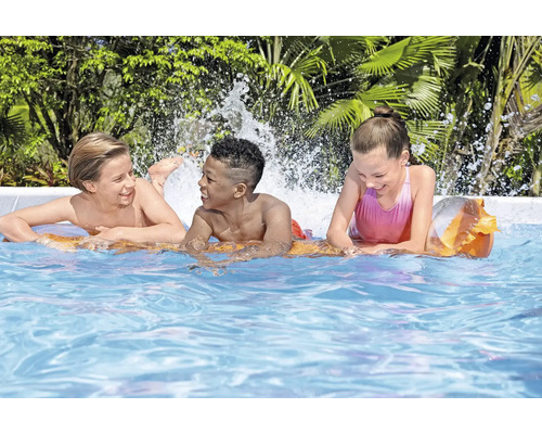 Drie kinderen spelen in het zwembad met waterspetters.