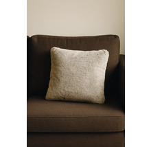 Vierkant sierkussen met imitatiebont op een bruine bank