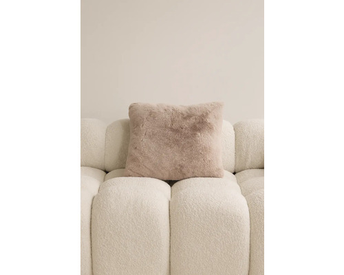 Vierkant sierkussen met een vachtuitstraling op een bank.