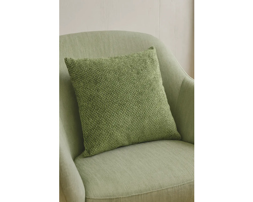 Groen sierkussen op een fauteuil