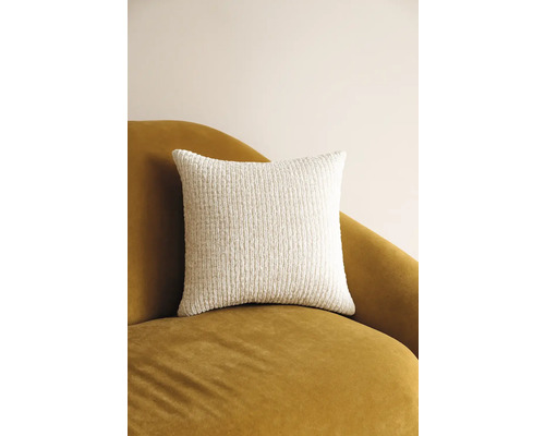 Vierkant decoratief kussen van gestructureerde stof op een fauteuil