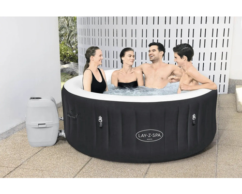Opblaasbare Lay-Z-Spa Miami whirlpool met vier personen in de tuin.