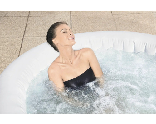 Vrouw ontspant in een opblaasbare whirlpool buitenshuis.