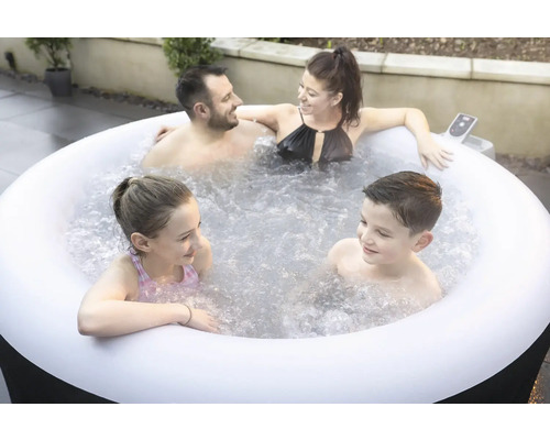 Familie ontspant in een opblaasbare jacuzzi buiten