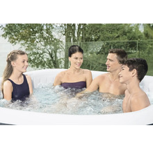 Familie ontspant in een opblaasbare jacuzzi buiten.