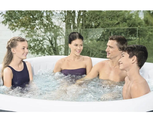Familie ontspant in een opblaasbare jacuzzi buiten.