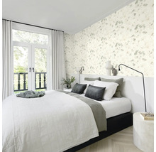 Slaapkamer met bloemenbehang, bed en openslaande deuren naar het balkon.