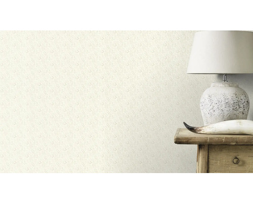 Close-up van een muur met een behang met bloemmotief, naast een lamp op een houten tafel