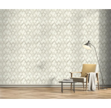 Woonkamer met geometrisch behang, fauteuil en vloerlamp.